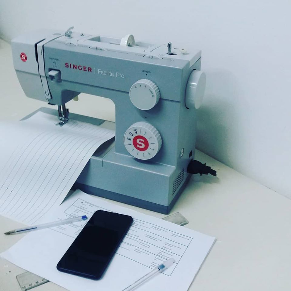 maquina de costura e celular treinando costurar reto